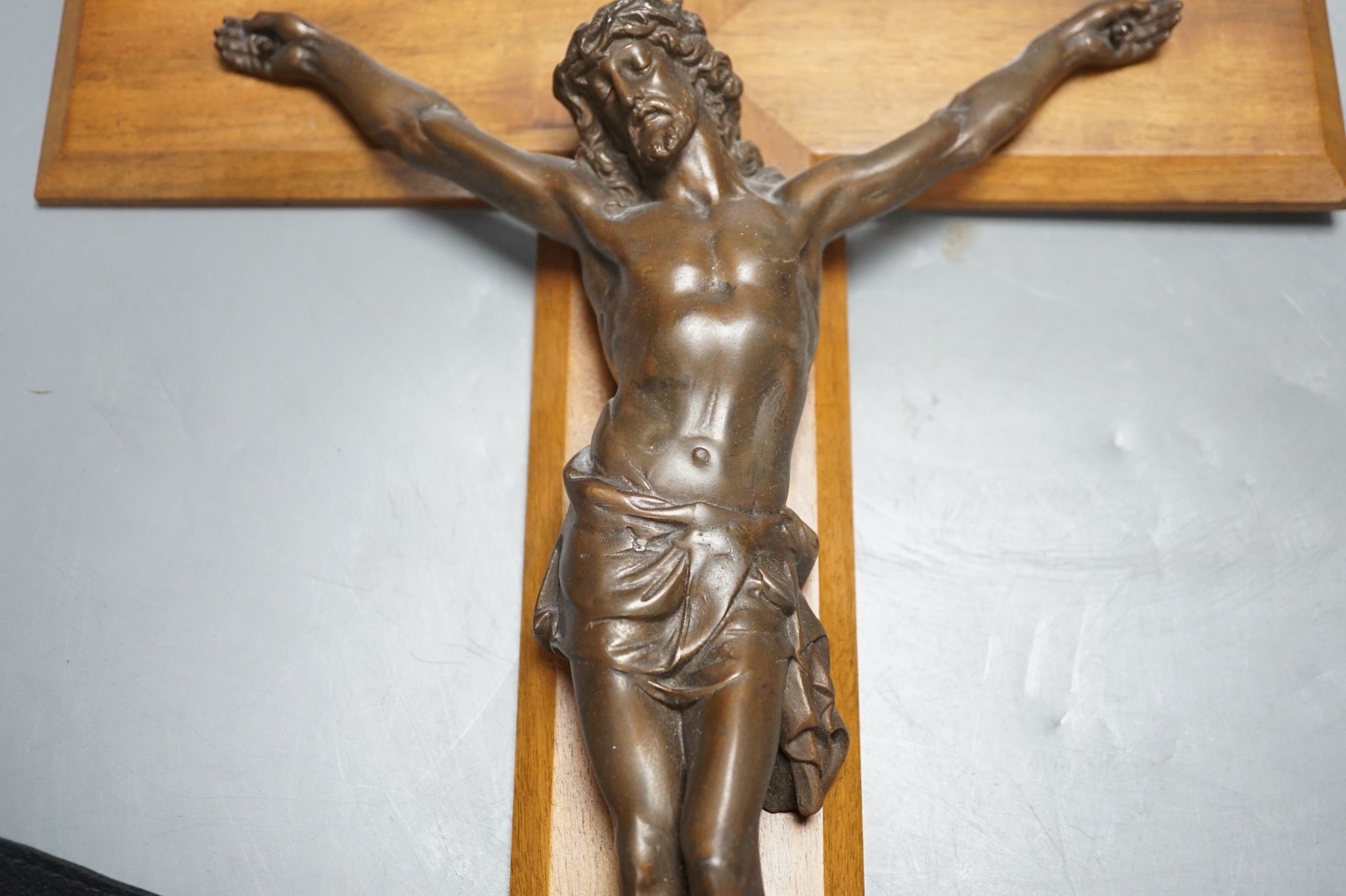 A bronze crucifix, mounted on a wooden cross, Height of cross, 60.5 cms.